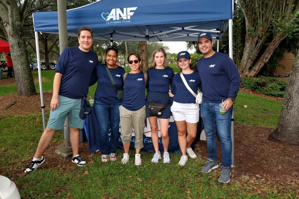 ANF team members in ANF Charitable Fund shirts under the fund's tent
